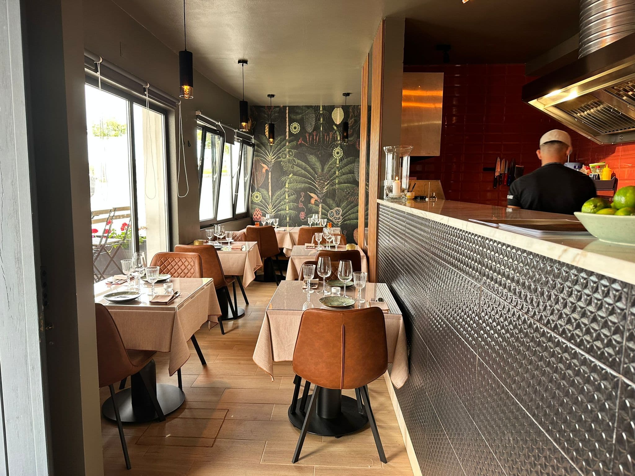 Interior da KAYA — a sala, o balcão e a cozinha aberta, à luz das velas